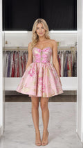 Front view of model wearing pink strapless floral brocade mini dress