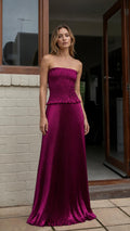 Front view of model wearing magenta strapless pleated two-piece maxi dress