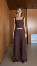 Front view of model wearing dark brown crop top and wide leg pants set