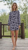 Front full view of woman wearing navy floral long sleeve shift dress