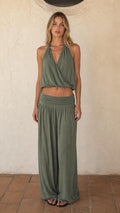Front view of woman wearing sage green halter crop top and wide leg pants set