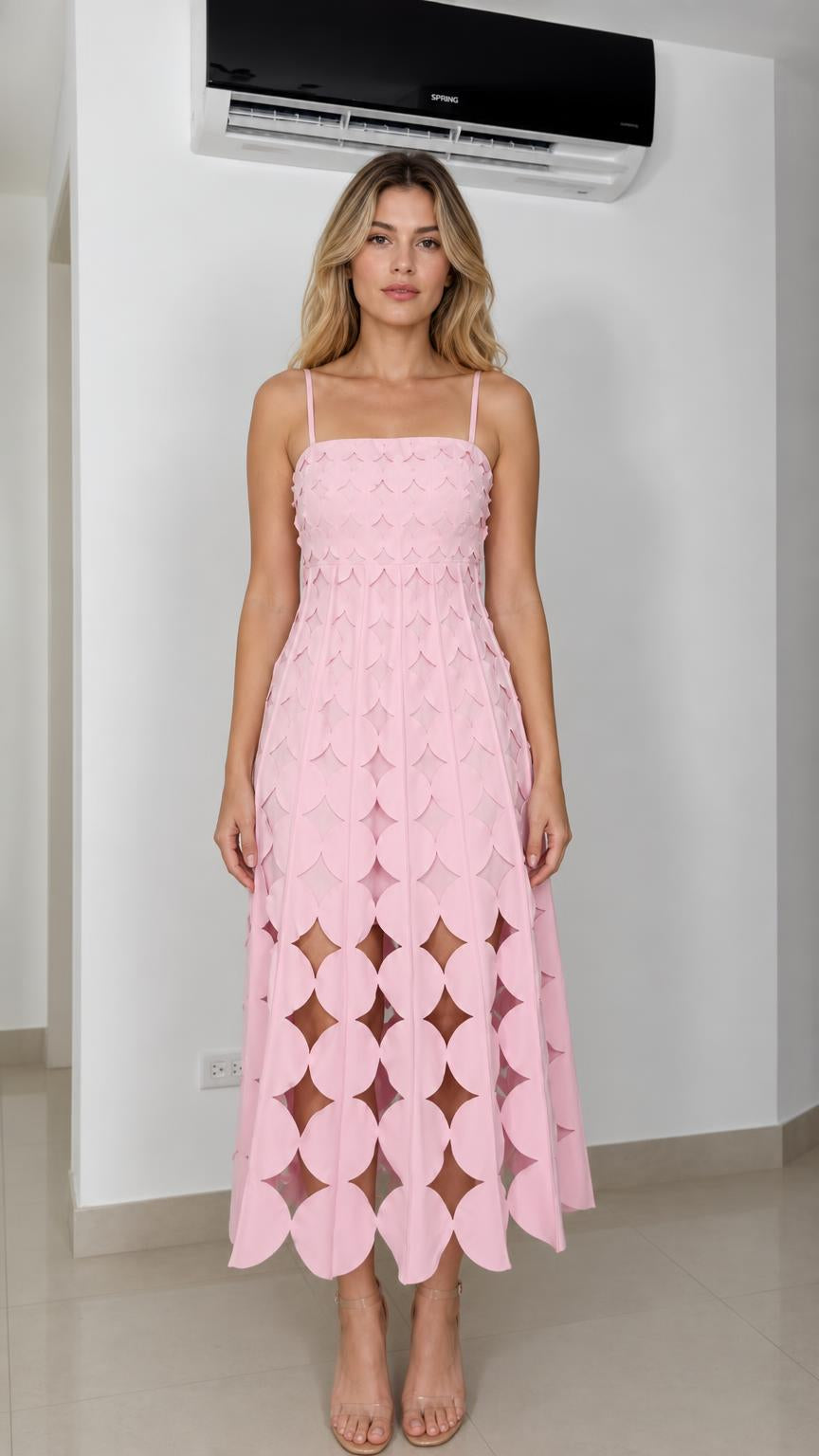 Front view of model wearing pink laser-cut geometric midi dress