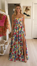 Front view of woman wearing white floral maxi dress with side slit