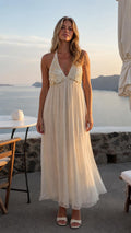 Front view of woman wearing ivory sequin halter neck maxi dress