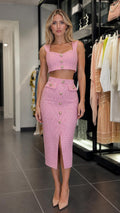 Front view of model wearing pink tweed crop top and midi skirt set
