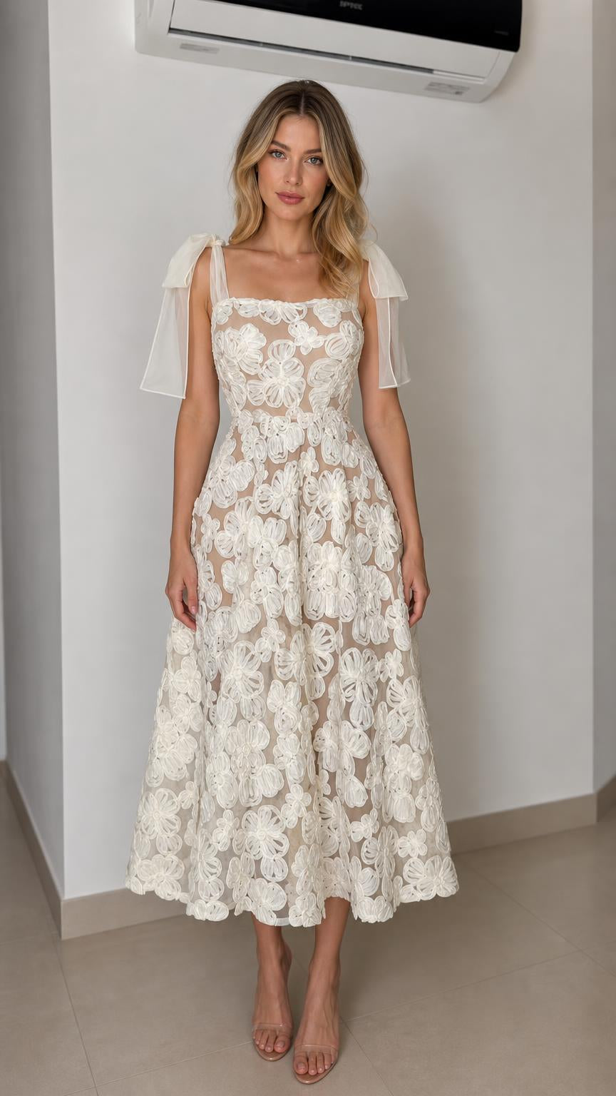 Front view of ivory floral applique midi dress with bow straps