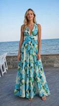 Front view of woman wearing blue floral V-neck maxi dress by the sea