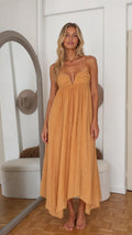 Front view of woman wearing mustard yellow halter ruched maxi dress