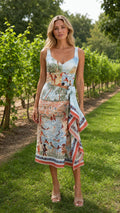 Front view of woman wearing light blue scenic print crop top and midi skirt set