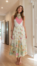 Front view of model wearing white floral midi dress with fringe accent