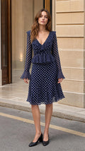 Front view of model wearing Navy polka dot midi dress