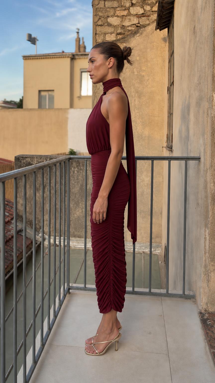 Side profile view of burgundy ruched dress with back tie detail