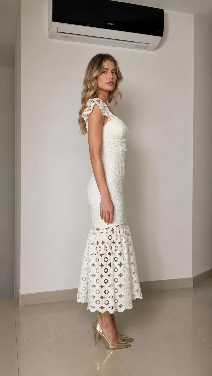Side profile view of woman wearing white lace midi dress with heels