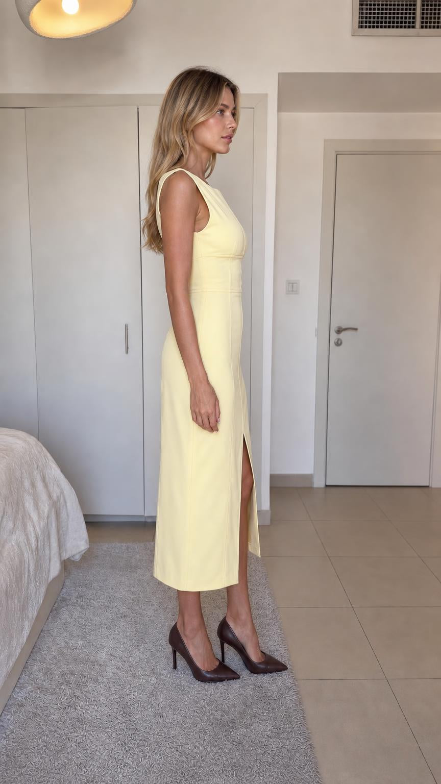Side profile view of yellow midi dress on model