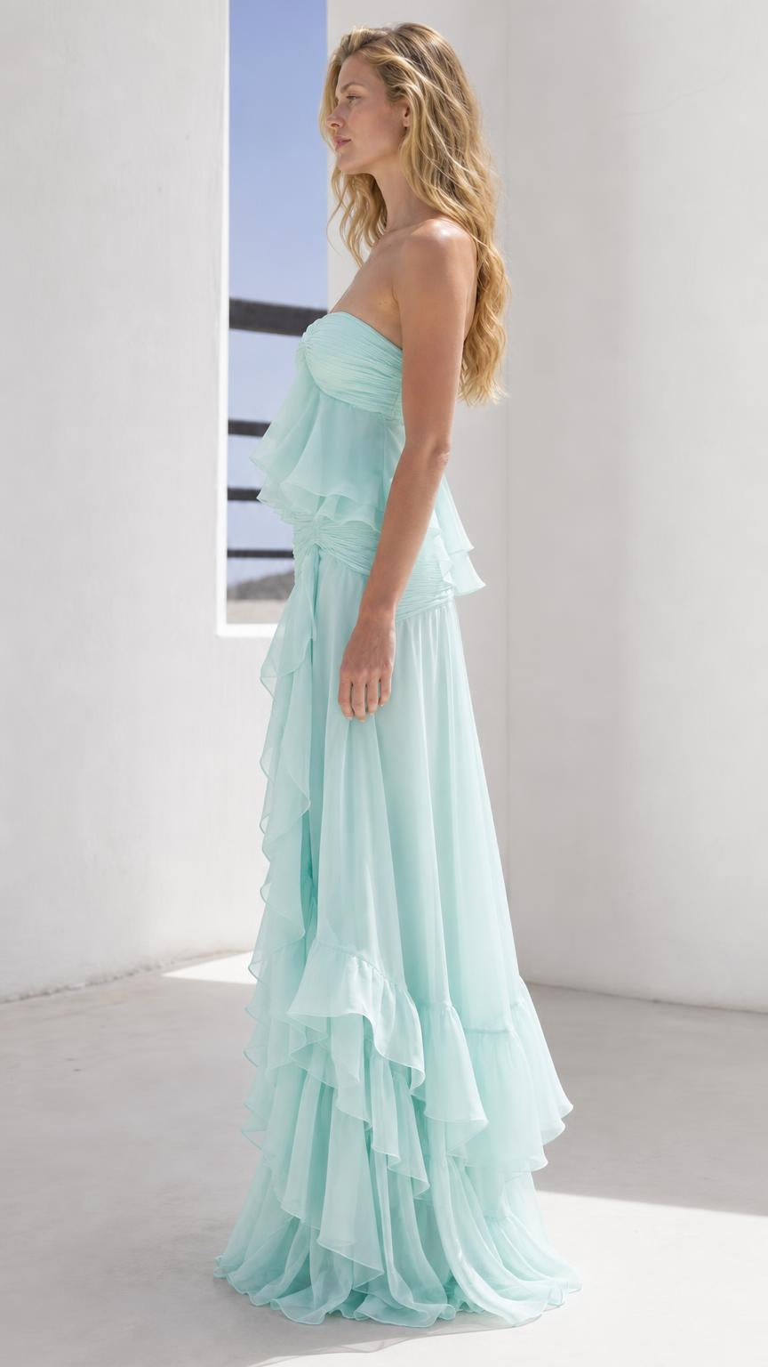 Side view of model wearing mint green strapless ruffled maxi dress