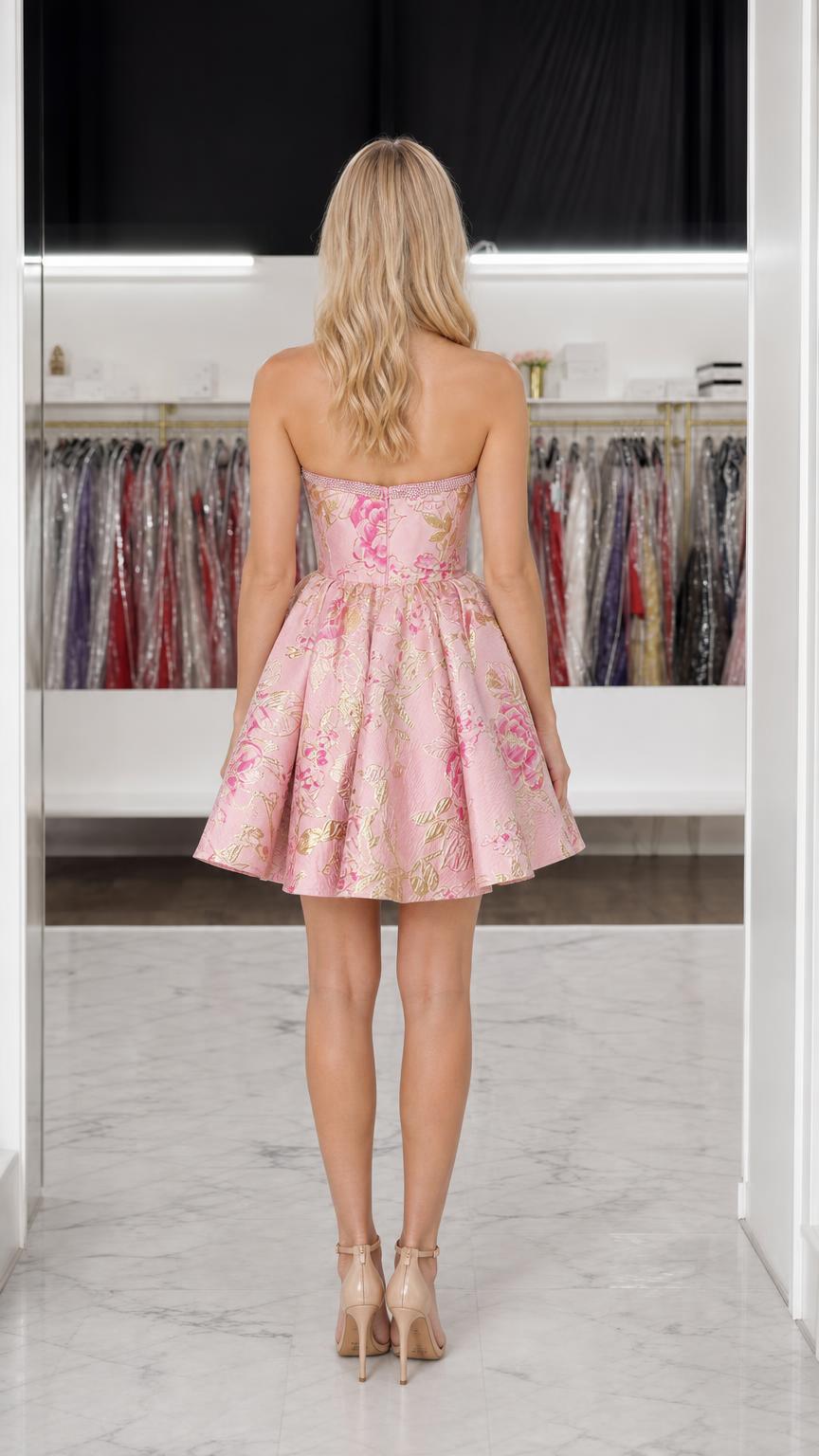 Back view of model showing strapless design of pink mini dress