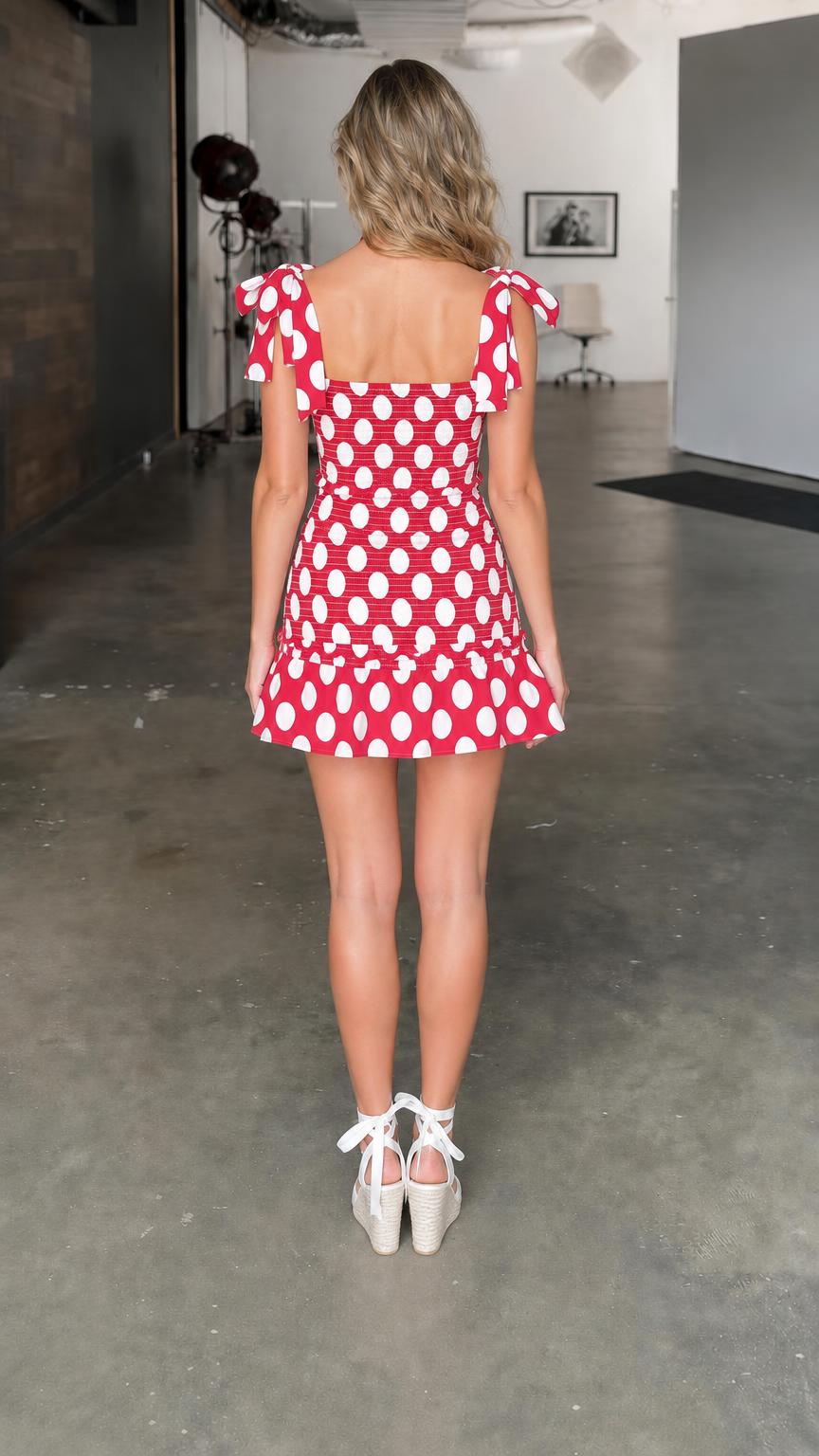 Model wearing red polka dot smocked mini dress, back view
