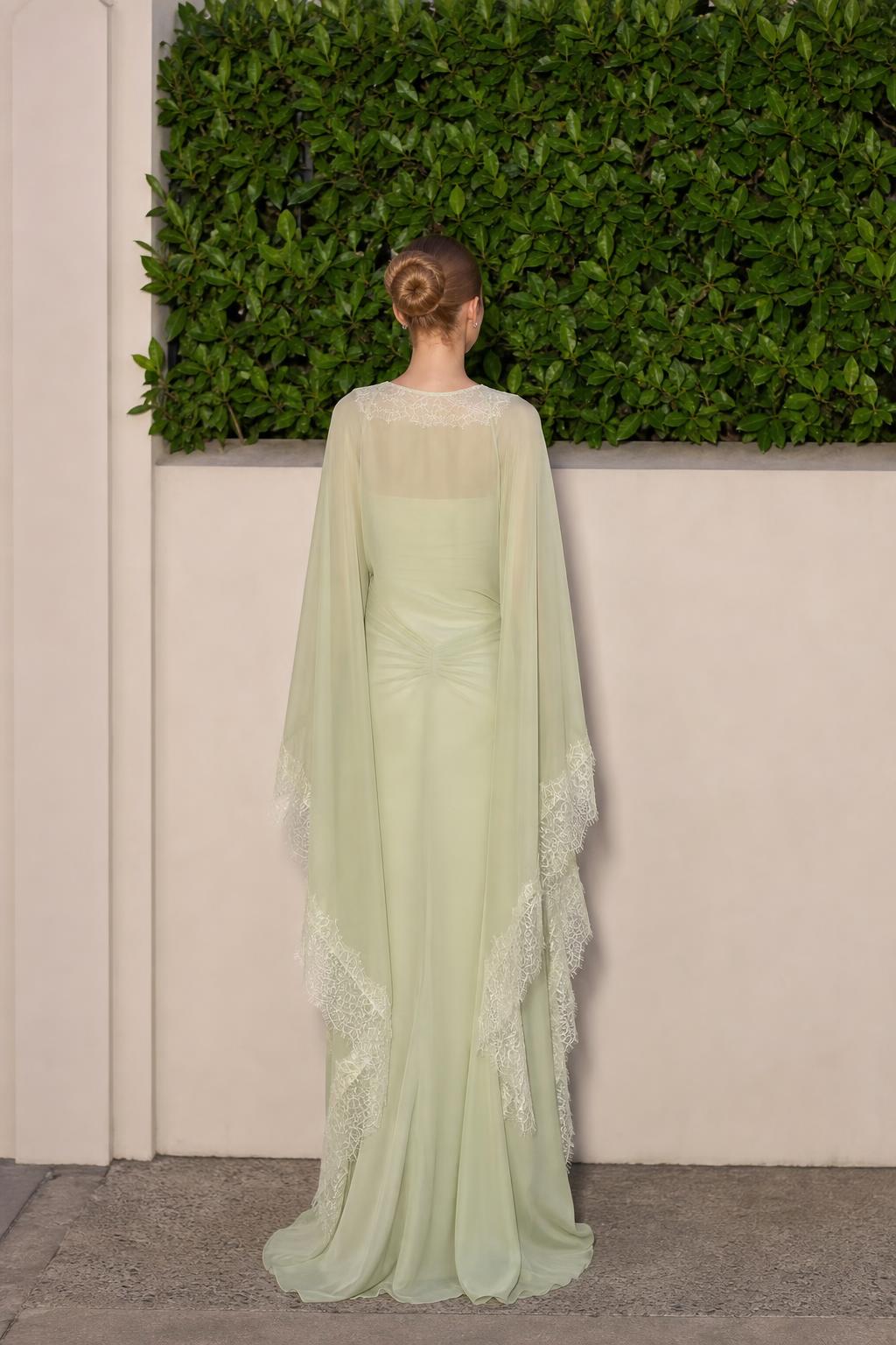 Model wearing sage green formal dress, back view