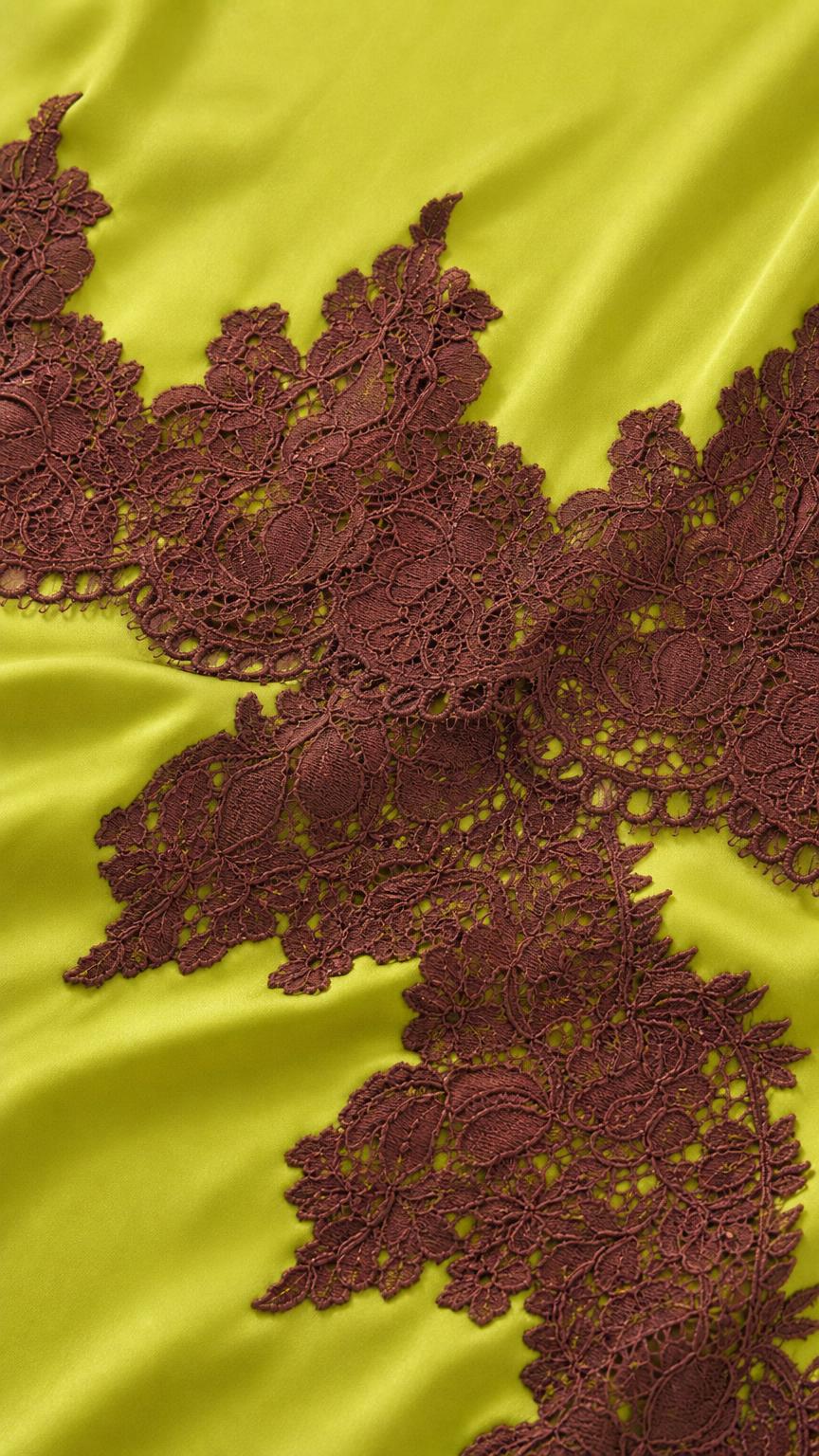 Close-up detail of dark brown lace applique on lime satin fabric