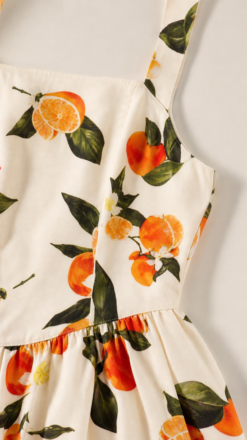 Close-up detail of fabric, square neckline, and citrus print