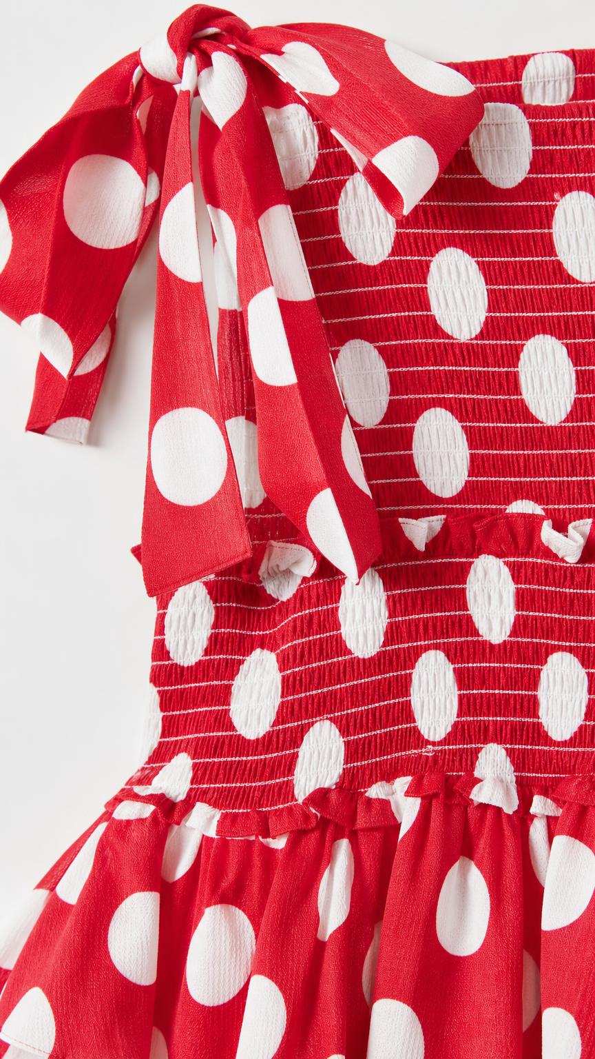 Close-up of red polka dot dress bodice and shoulder tie bow