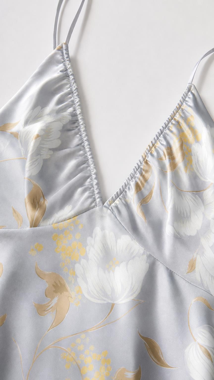 Close-up detail of V-neckline and floral print on satin fabric