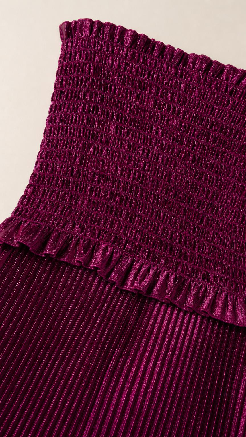 Close-up detail of smocked bodice and pleating texture in magenta