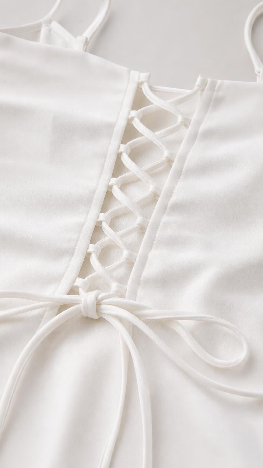Close-up detail of lace-up back tie on the white cami top