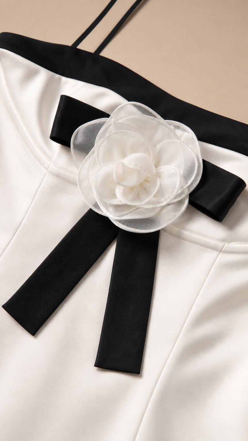 Close-up of neckline, bow, and rose brooch detail