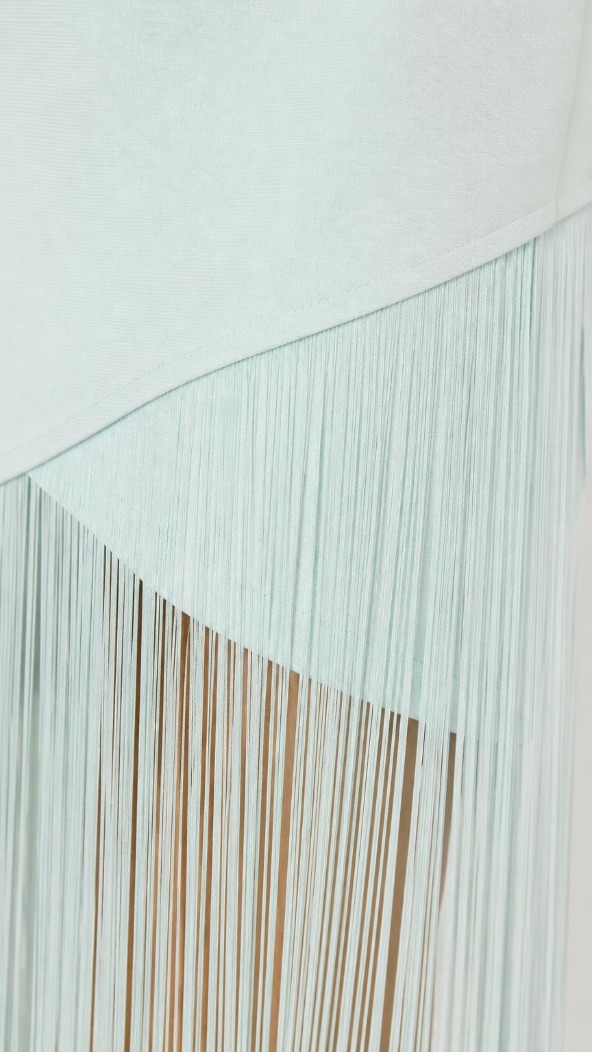 Close-up detail of mint asymmetric fringe hem