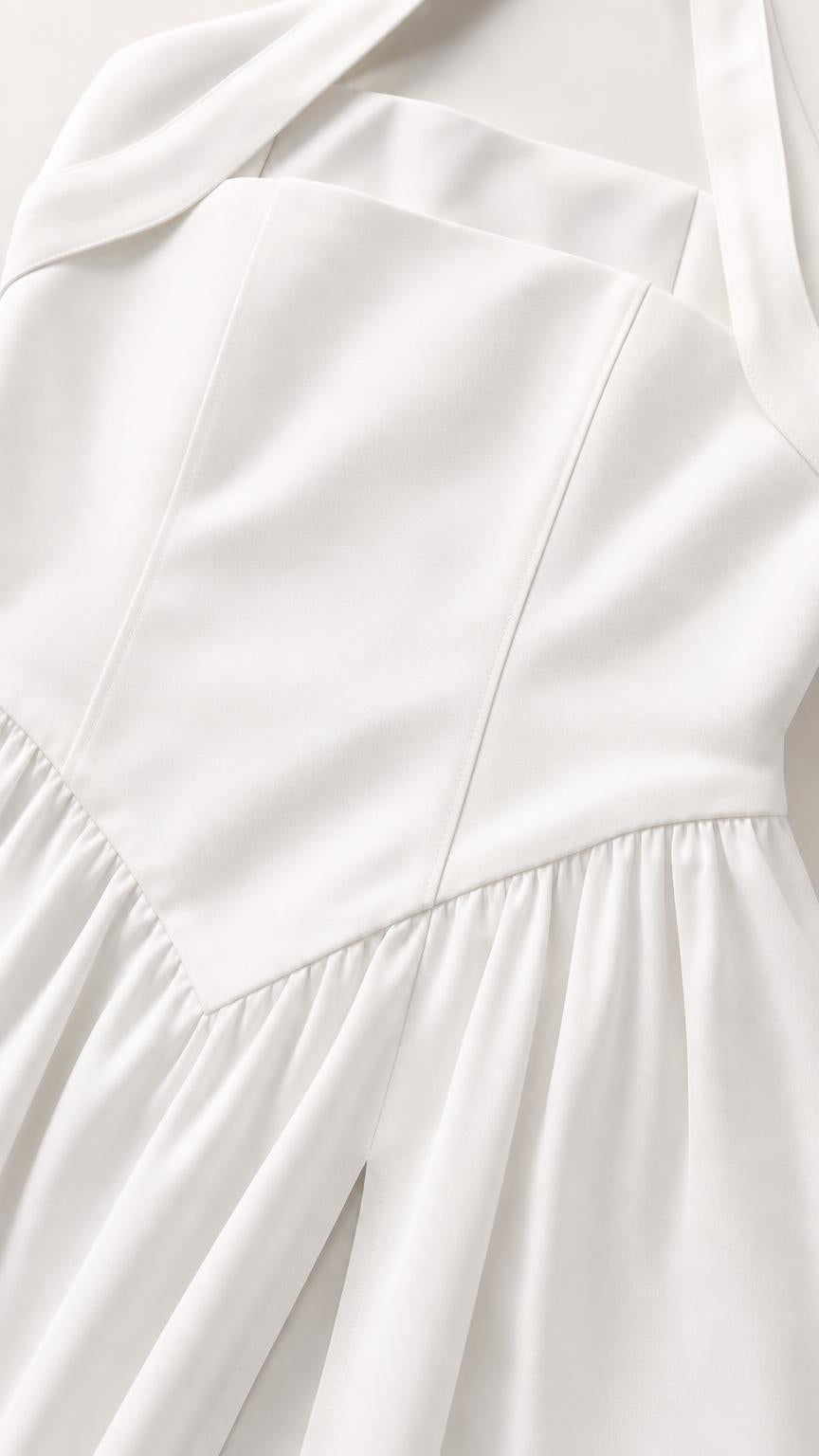 Close-up detail of the structured bodice and fabric on white dress