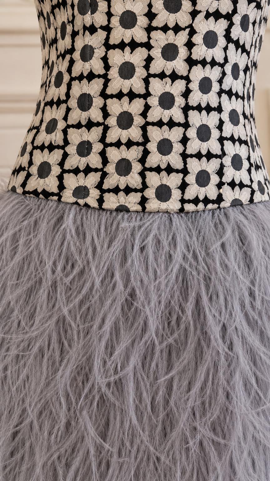Close-up detail of the floral embroidered bodice and feather skirt
