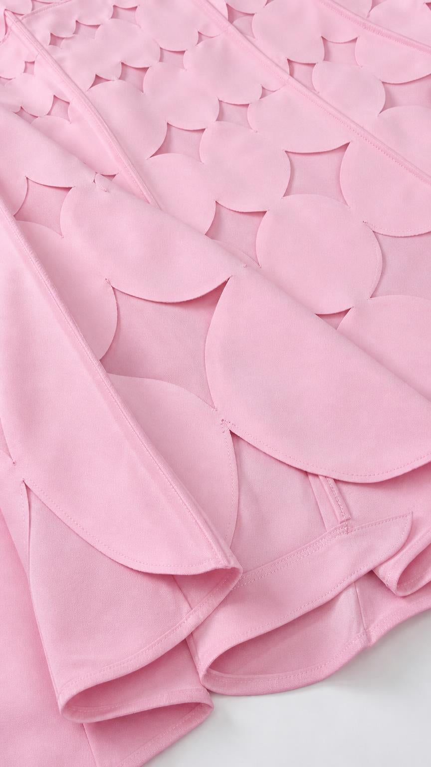 Close-up of pink fabric texture and scalloped geometric cutouts