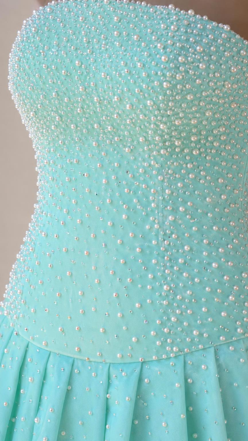 Close up of pearl embellishment on mint dress