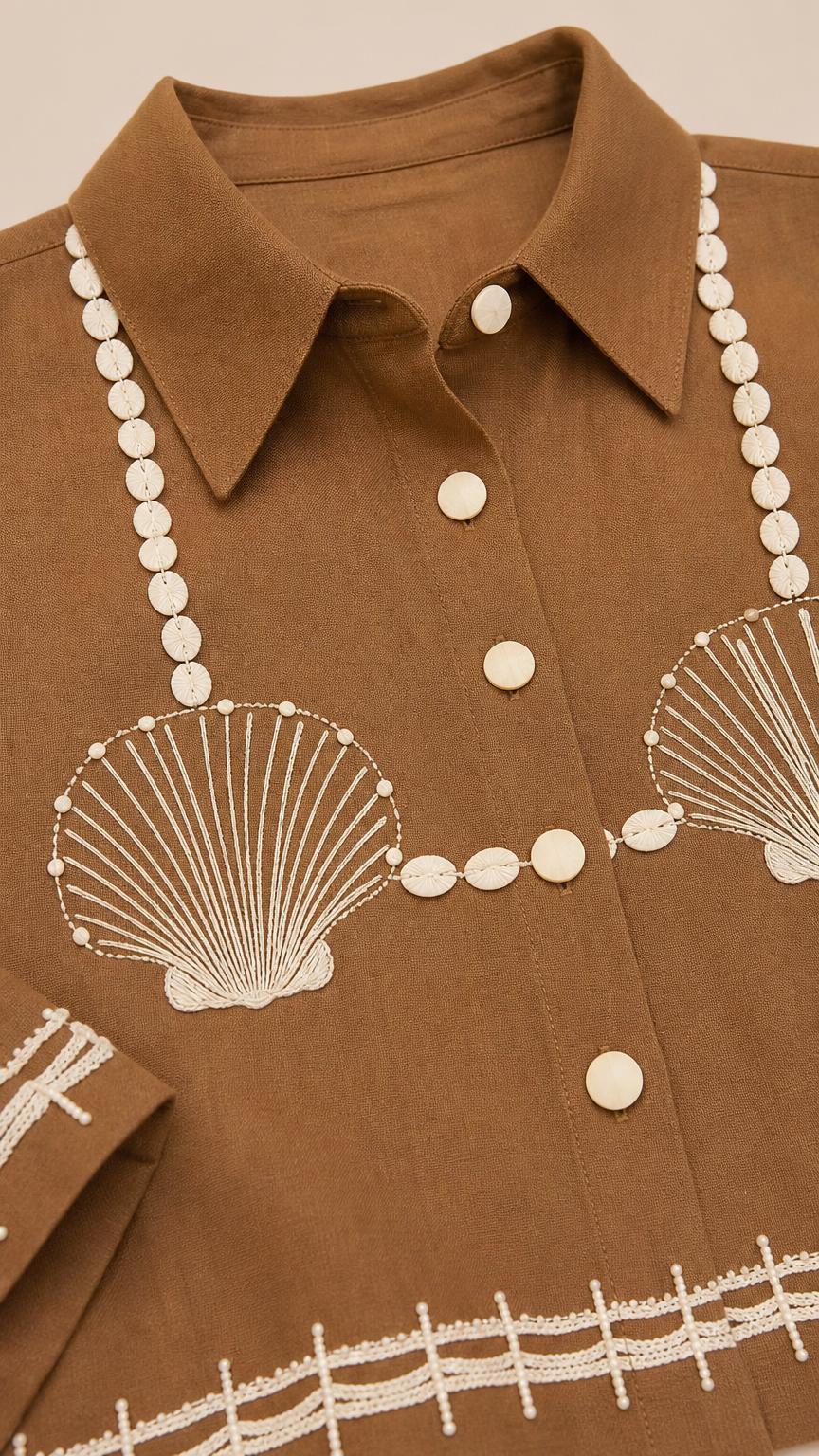 Close-up detail of lapel collar and shell embroidery on brown top