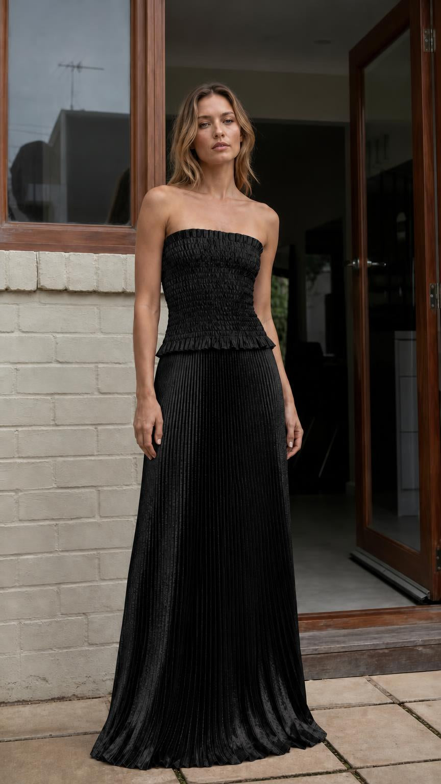 Model wearing black strapless pleated two-piece maxi dress