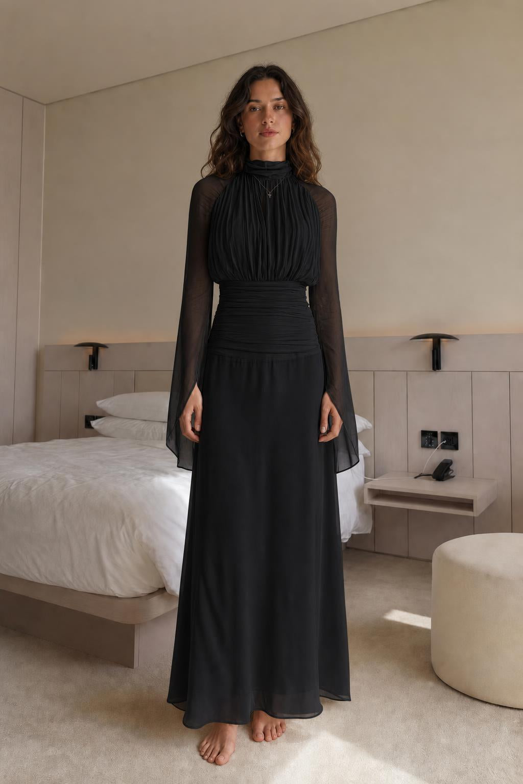 Front view of woman wearing black pleated long-sleeve maxi dress