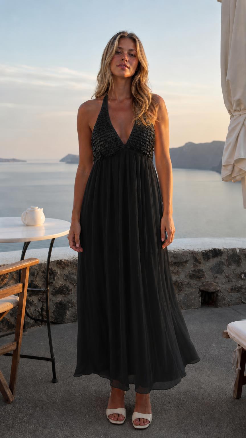 Front view of woman wearing black sequin halter neck maxi dress