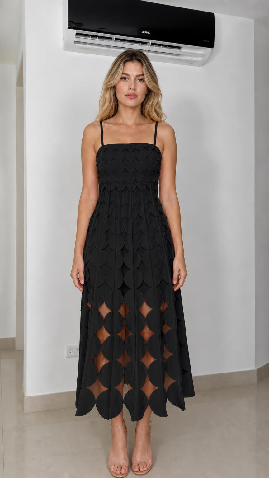 Front view of model wearing black laser-cut geometric midi dress
