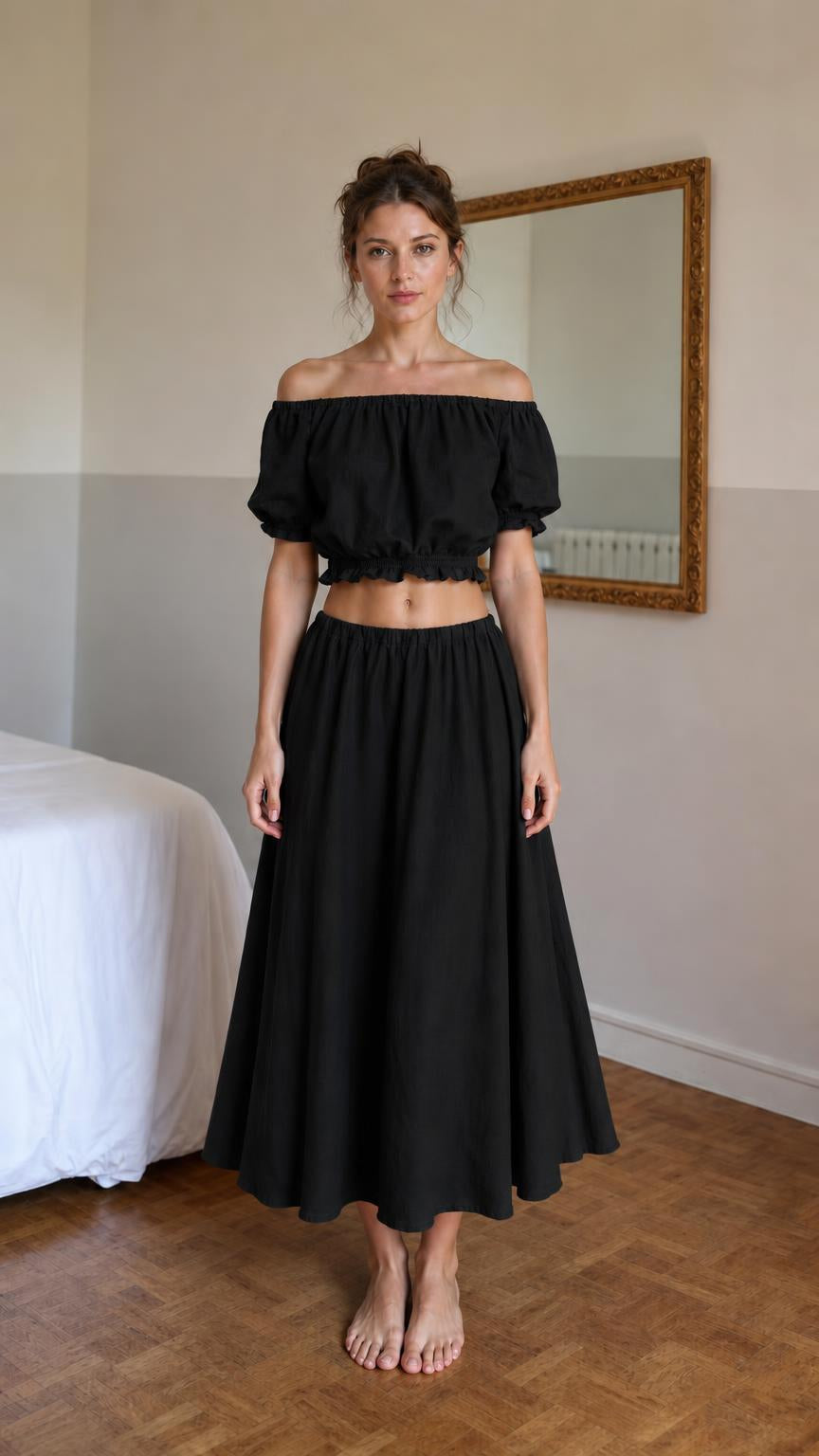 Front view of woman wearing black off-shoulder crop top and midi skirt set
