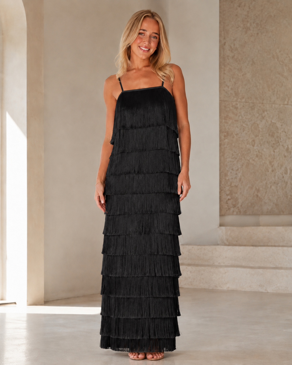 Full front view of black tiered fringe maxi dress with cami straps