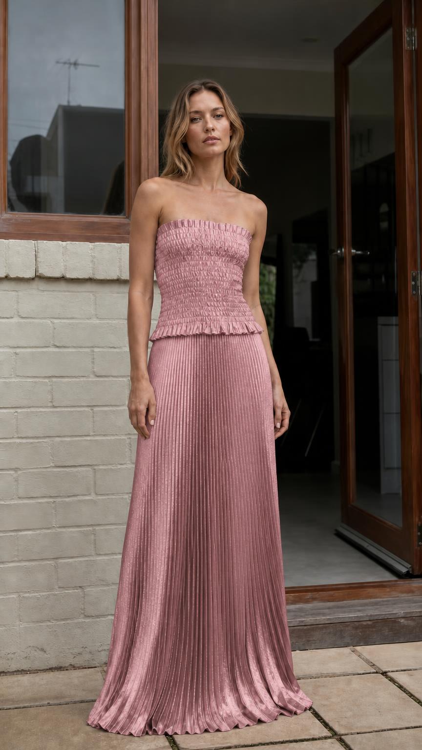 Model wearing dusty pink strapless pleated two-piece maxi dress
