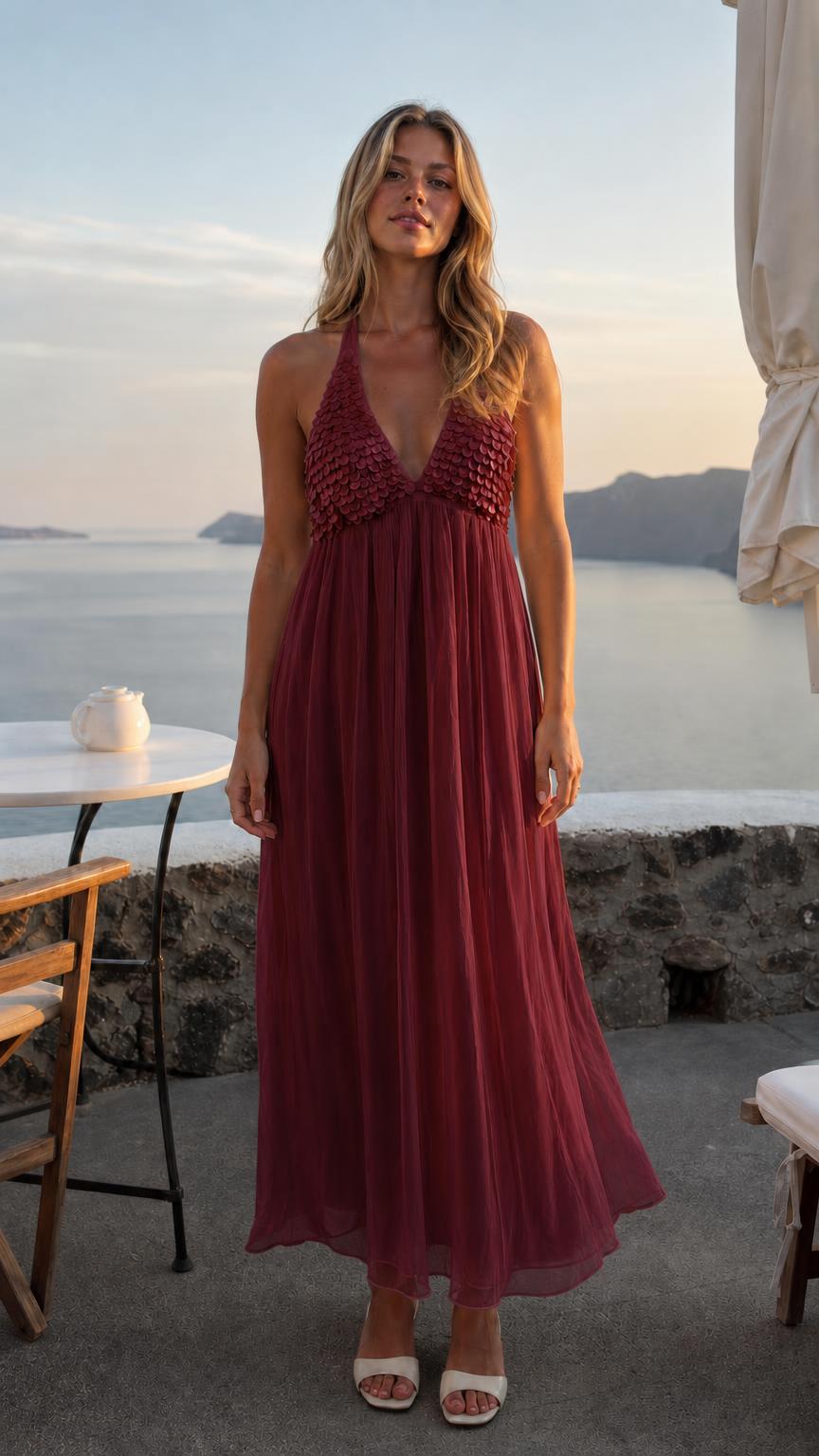 Front view of woman wearing burgundy sequin halter neck maxi dress
