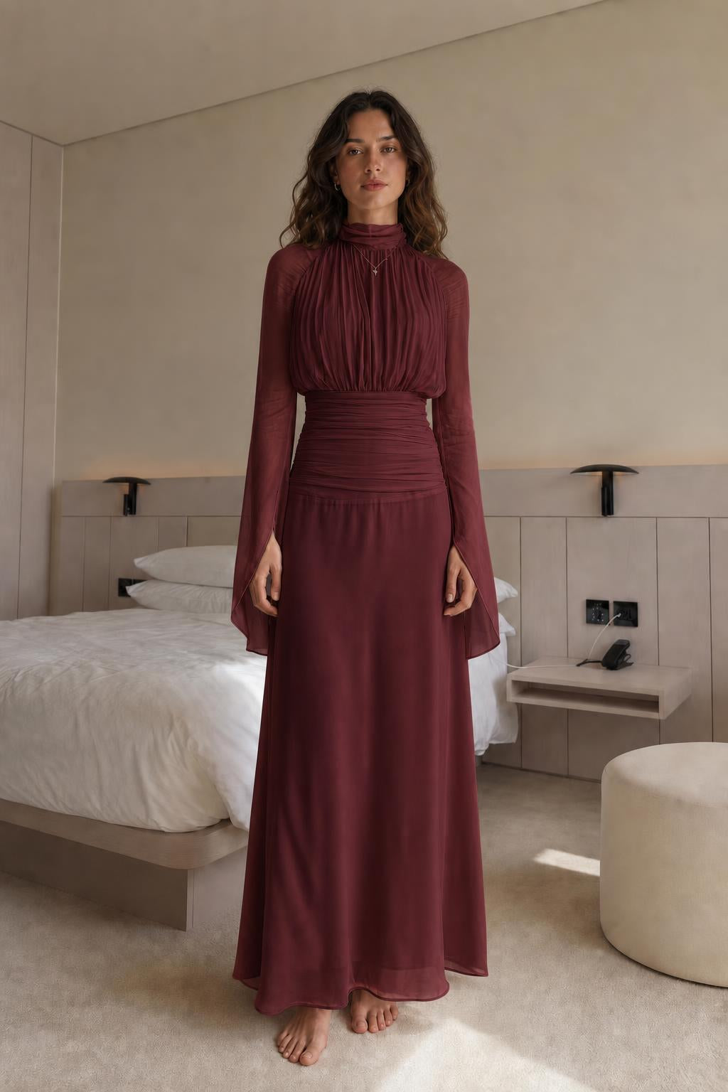 Front view of woman wearing burgundy pleated maxi dress