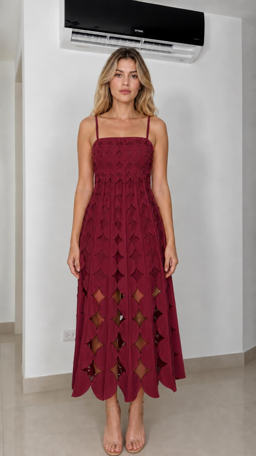 Front view of model wearing burgundy laser-cut geometric midi dress