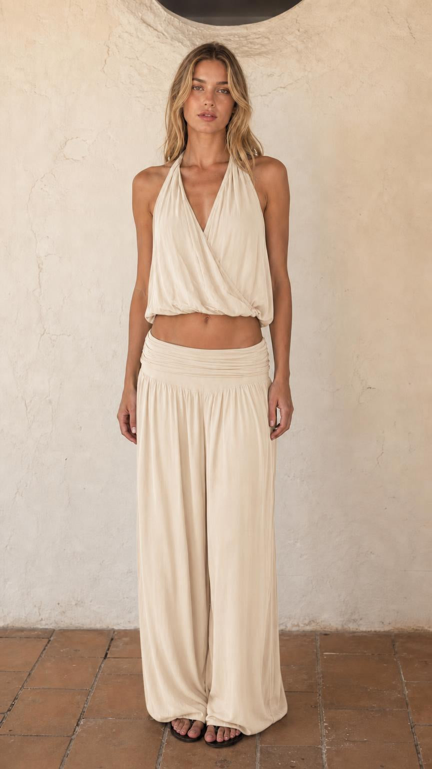 Woman wearing beige halter crop top and wide leg pants set